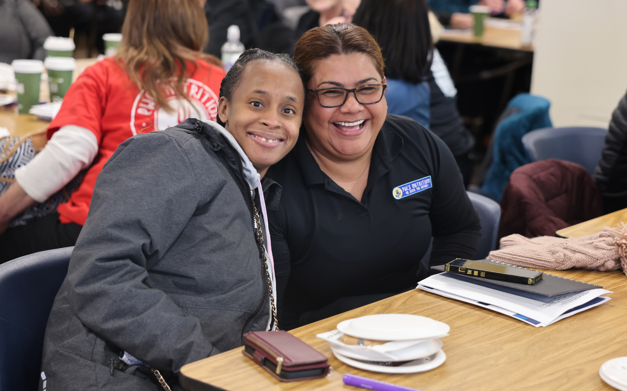 Cafeteria managers smiling at a staff meeting.