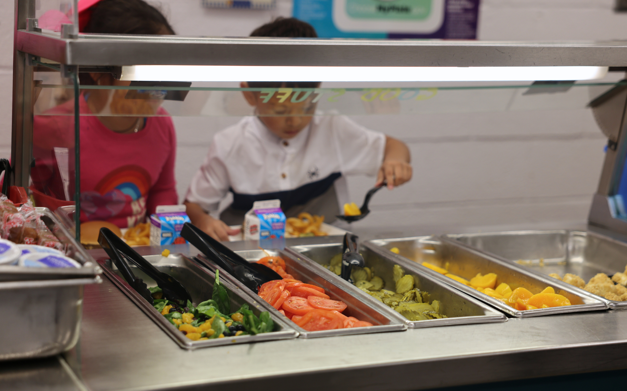 Student selecting fruits and vegetables at the garden bar.