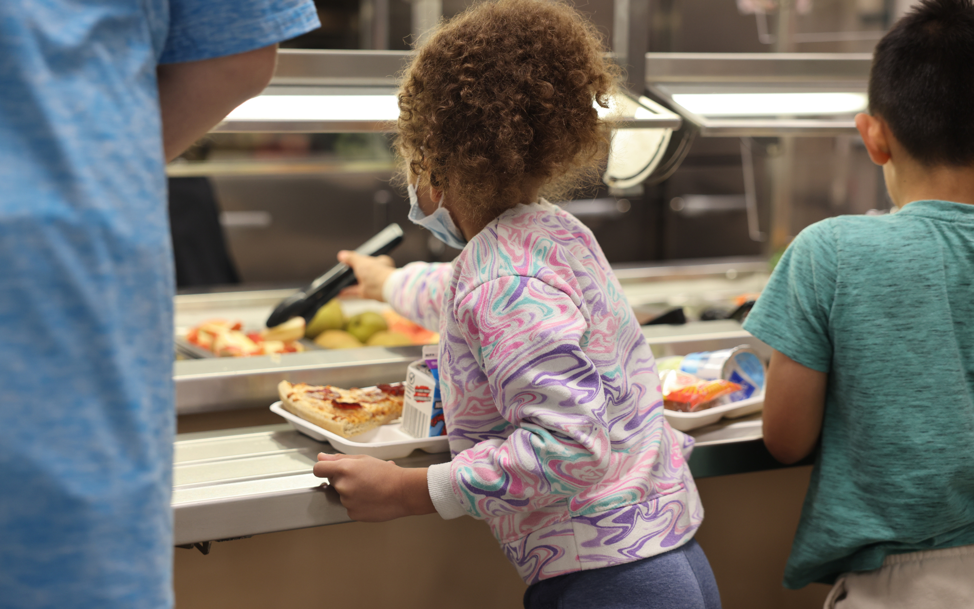 Elementary student serving herself at the garden bar.