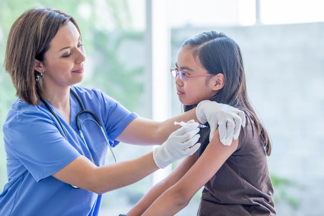 Nurse giving a young girl a vaccination