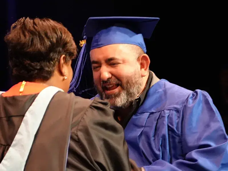 Student receiving their diploma at the 2025 adult education graduation ceremony