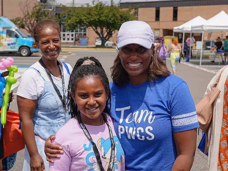 Superintendent Dr. McDade posting for a photo with a student at the 2025 PWCS Community Event