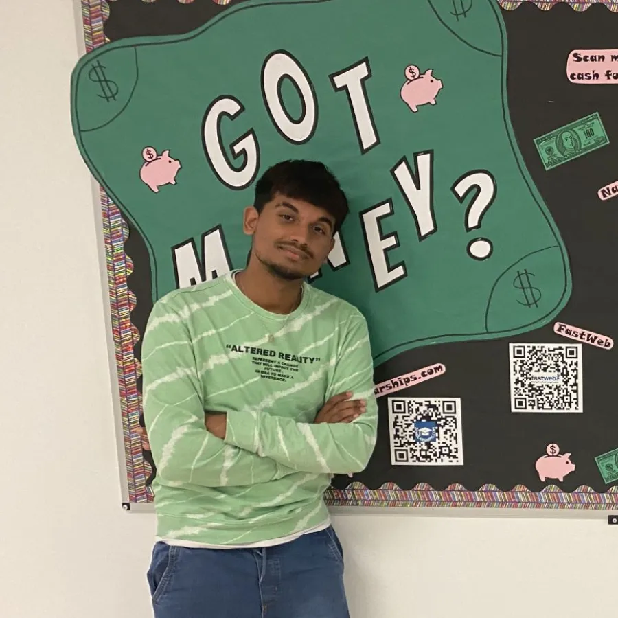 Male senior student standing in front of bulletin board promoting National Scholarship Month