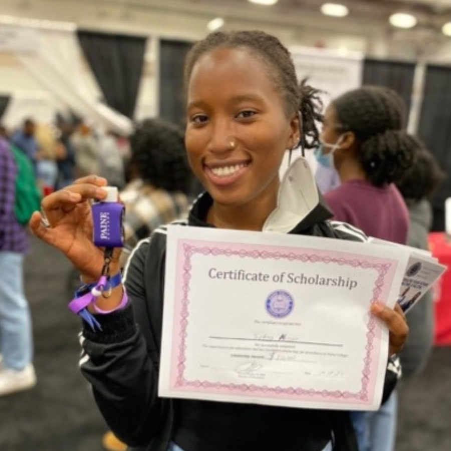 Female senior student holding up scholarship award certificate