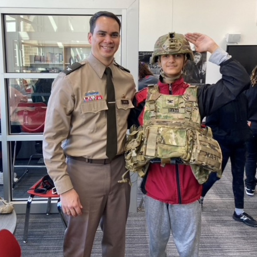 military parent standing with student wearing military gear