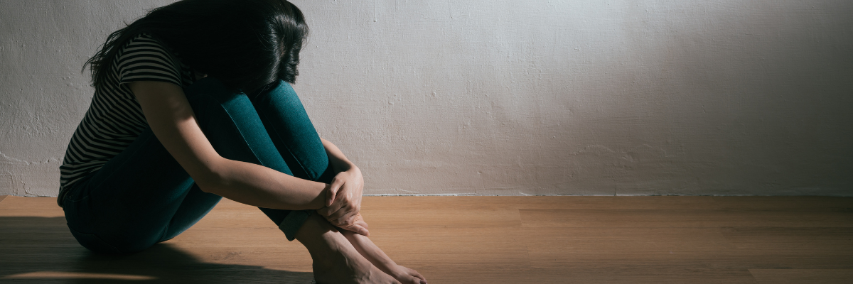 photo of girl sitting on floor with head in her hands