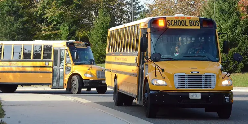 School bus pulling up to bus lane to drop students off at school