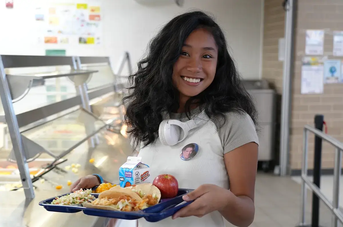 High school student holding a school lunch tray