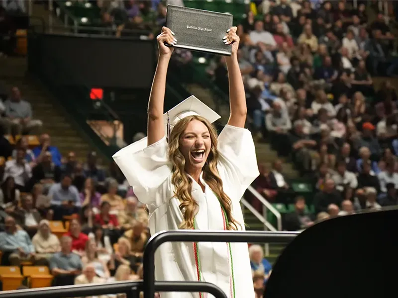 2025 Battlefield High School graduate holding her diploma above her head