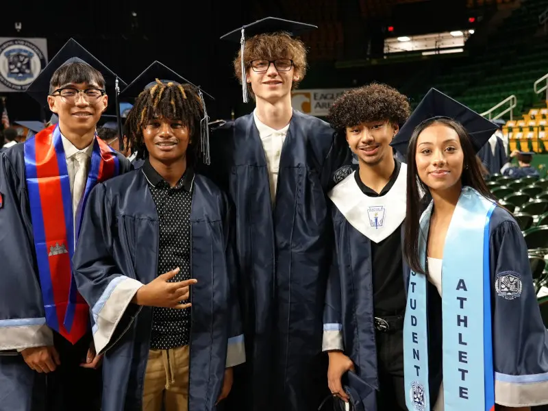 High school students posing for a photo at graduation