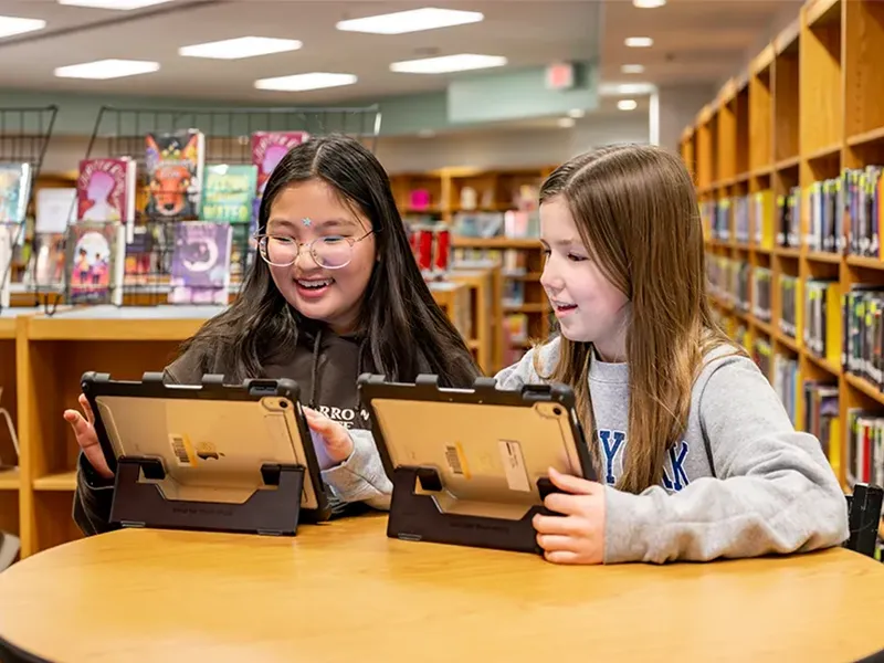 Middle school students working on their iPads in the school library