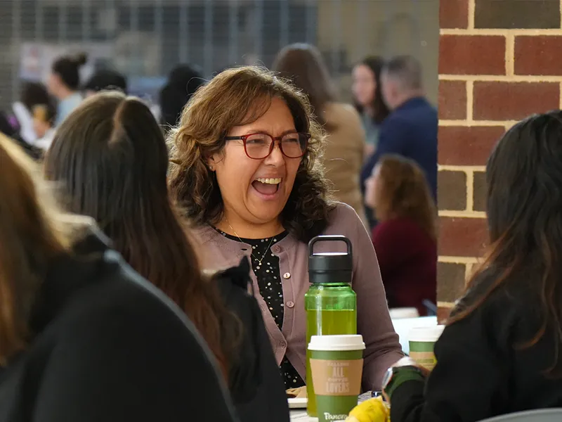 Support staff member laughing during a break at the Classified Professional Development Conference