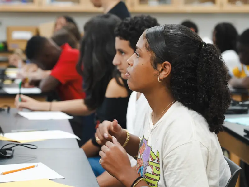 High school student seated at a desk engaged on the first day of school