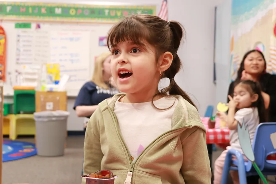 Young elementary school student seated in a classroom while talking