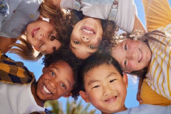 Children looking downward in a circle