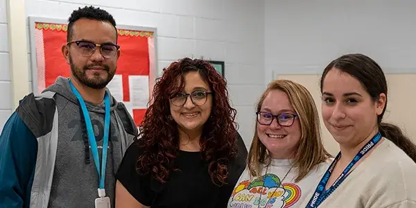 Group of English learner teachers standing in a school building