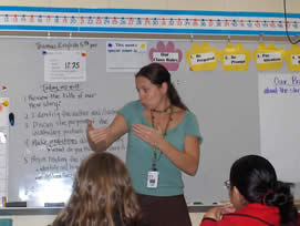 Female teacher using sign language to teach in a classroom.
