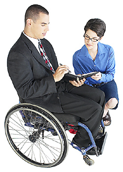 Man sitting in a wheelchair with a woman crouching next to him
