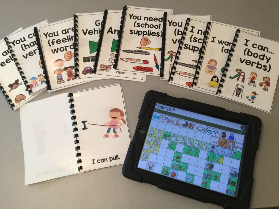 An iPad with a communication application called LAMP, with some literacy books around the iPad.