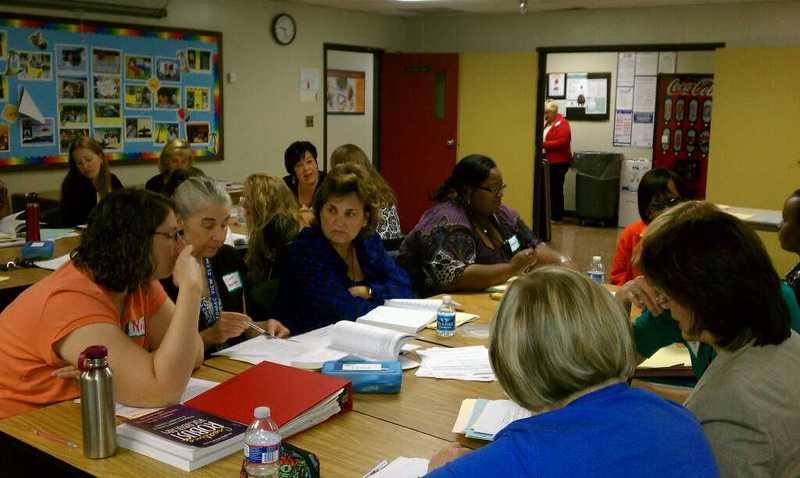 Teachers having a discussion in a classroom setting.
