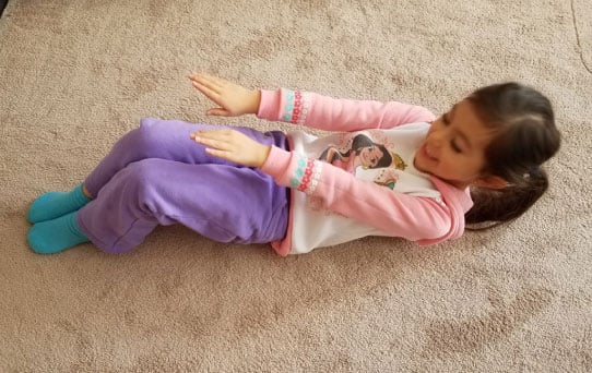 A female student doing a sit-up on the floor