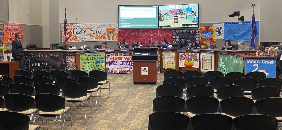 School Board Members at the dais with the SB member appreciation art hung up around them.