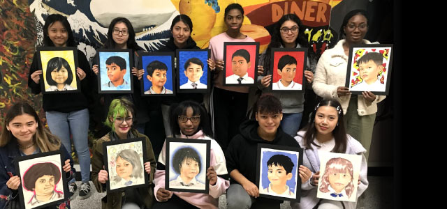 11 Hylton students holding their portraits