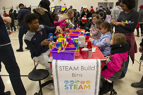 Students sitting at a table working on projects in the STEAM bins