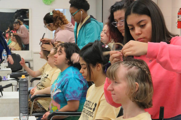Cosmetology students doing the hair for students in the unified sports program