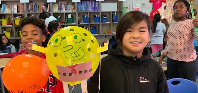 Two students holding balloons