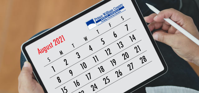 Hands holding an iPad showing the calendar for August 2021