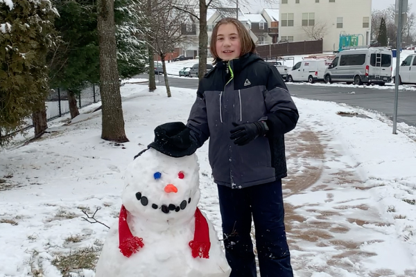 Travis Perweiler and his snowman, Max standing outdoors