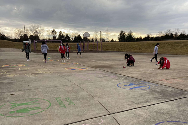 Students drawing chalk art