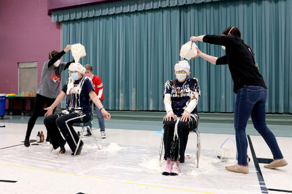 Ice cream sundae ingredients poured on principal by winning class