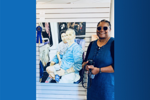 Art teacher Beryl Jazvic standing with her artwork that earned Best In Show award