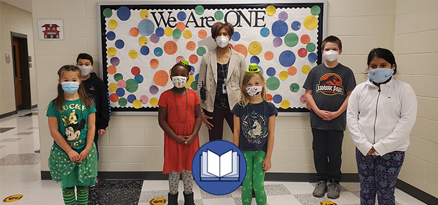 Students in front of We Are One Bulletin Board