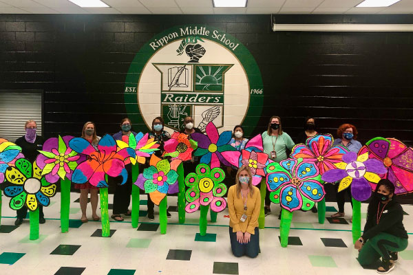 Teachers in Rippon Middle School's cafeteria, with giant flower sculptures