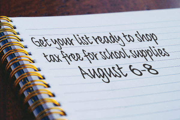 Notebook with writing that reads, "Get your list ready to shop tax-free for school supplies August 6 - 8."