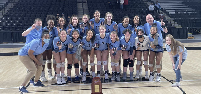 Colgan girls volleyball team holding state medals standing behind state trophy