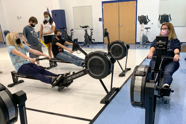 Photo of students and instructor on rowing machines