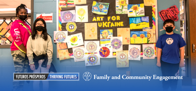 Chris Yung Elementary School students standing next to an Art for Ukraine display