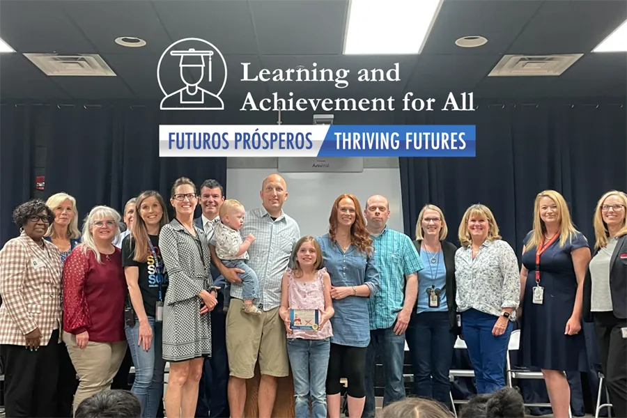 Smiling photo of Leila Walton, third-grade student at Ashland Elementary School, holding a glass image of her national winning cybersafety poster and surrounded by family and Virginia state officials who presented at the award ceremony