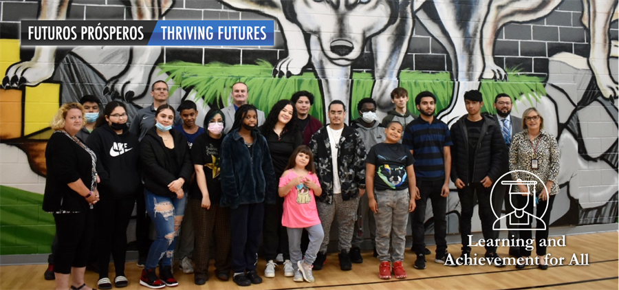 Students, staff, and families standing in front of a mural at Independence Nontraditional School