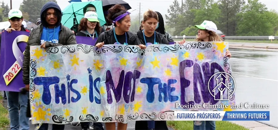 Forest Park students walking in rain with banner "This is not the end."