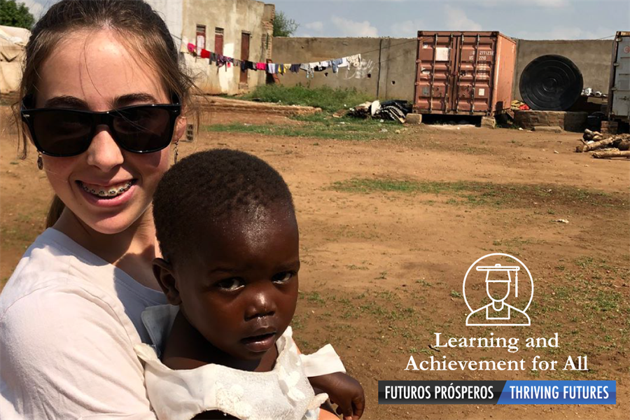 Smiling face of Patriot High School student Bridget Thaller in Africa holding a young child
