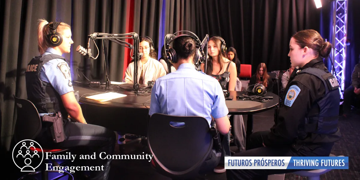 2 students and 3 police officers sitting at table with microphones