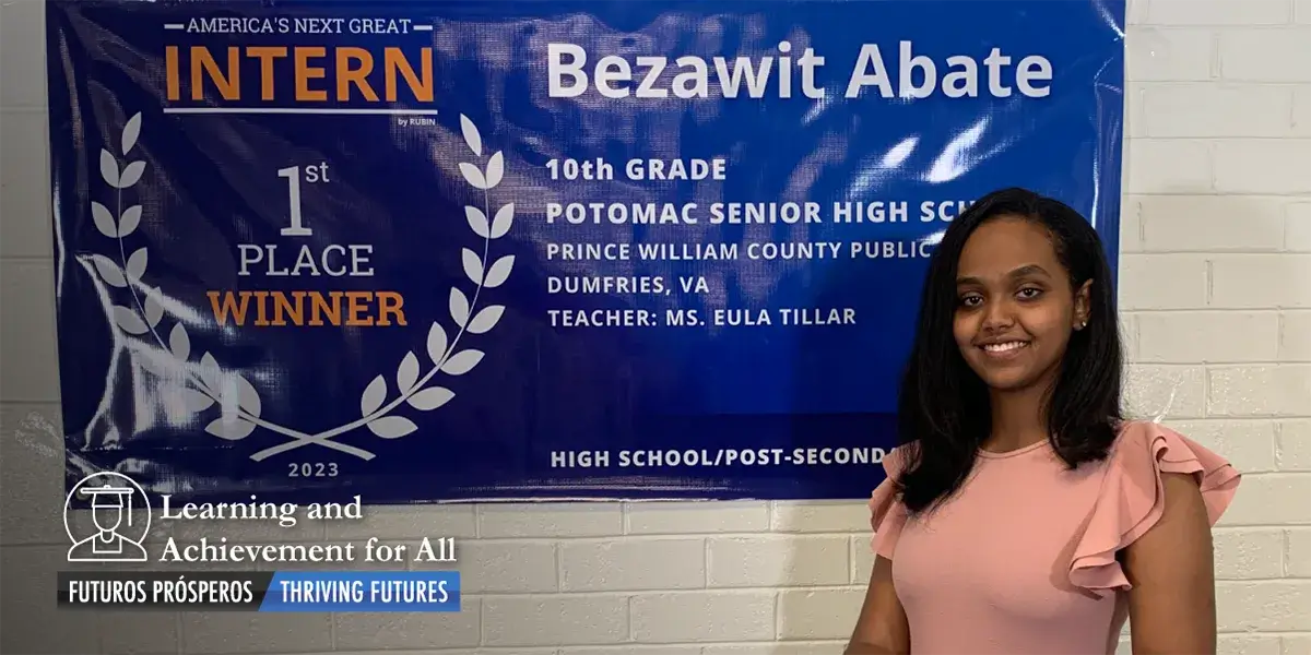 Bezawit Abate standing in front of a congratulatory banner 