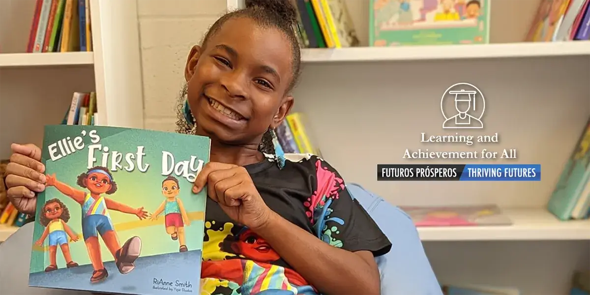 RiAnne Smith holding the book she wrote, "Ellie's First Day"