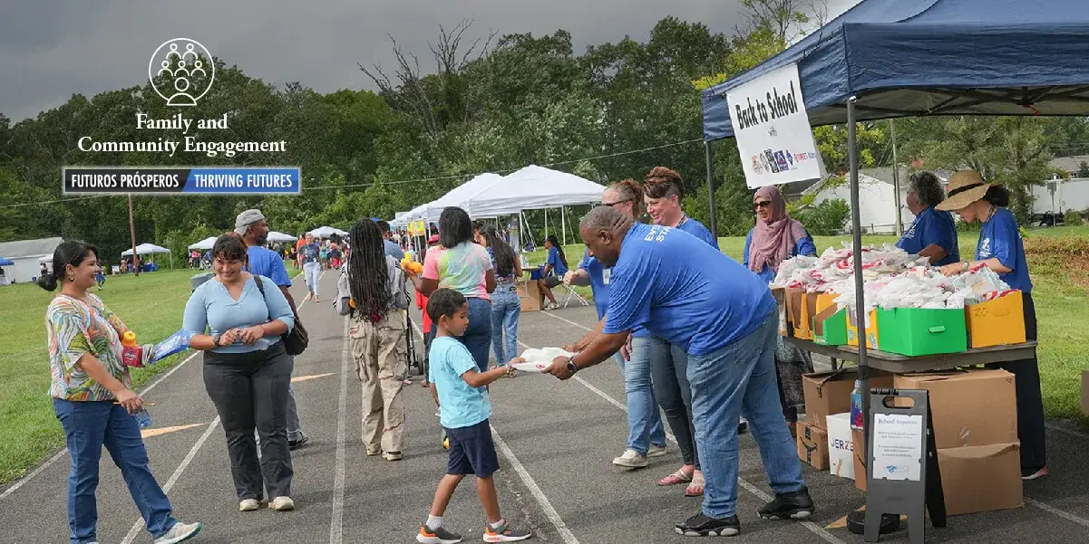 child receiving school supplies from PWCS staff at Unity Braxton middle school