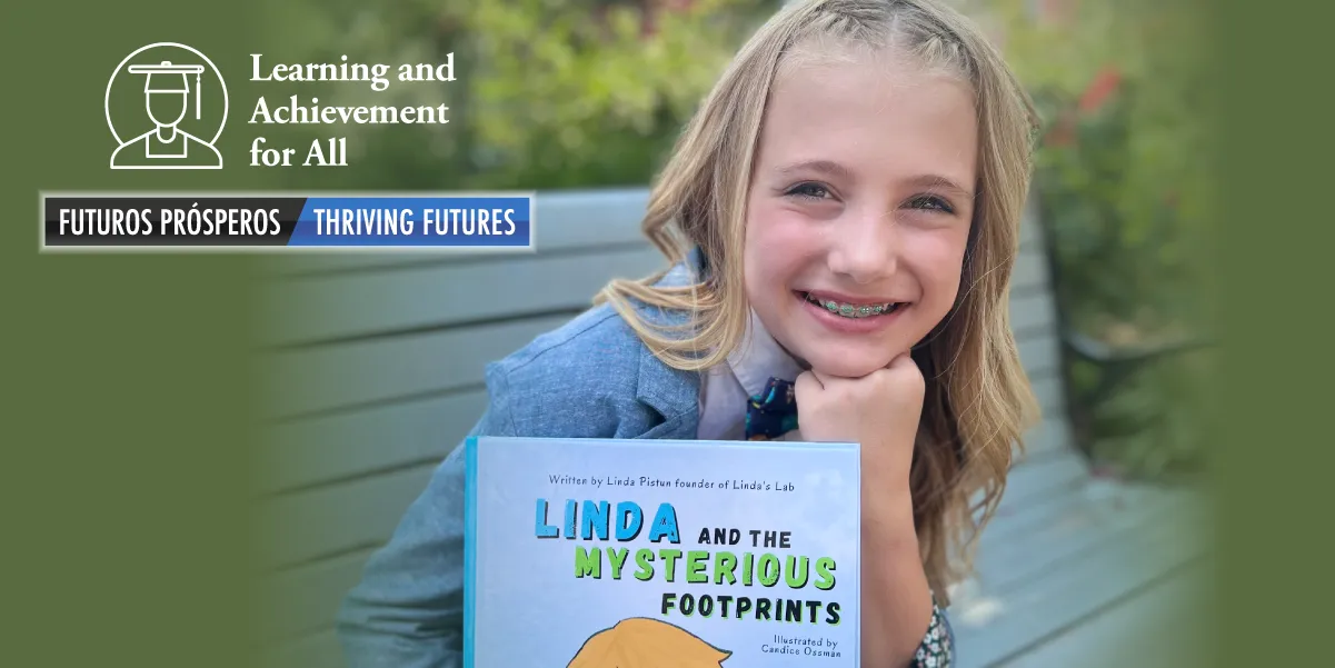 Linda holding her book "Linda and the Mysterious Footprints"